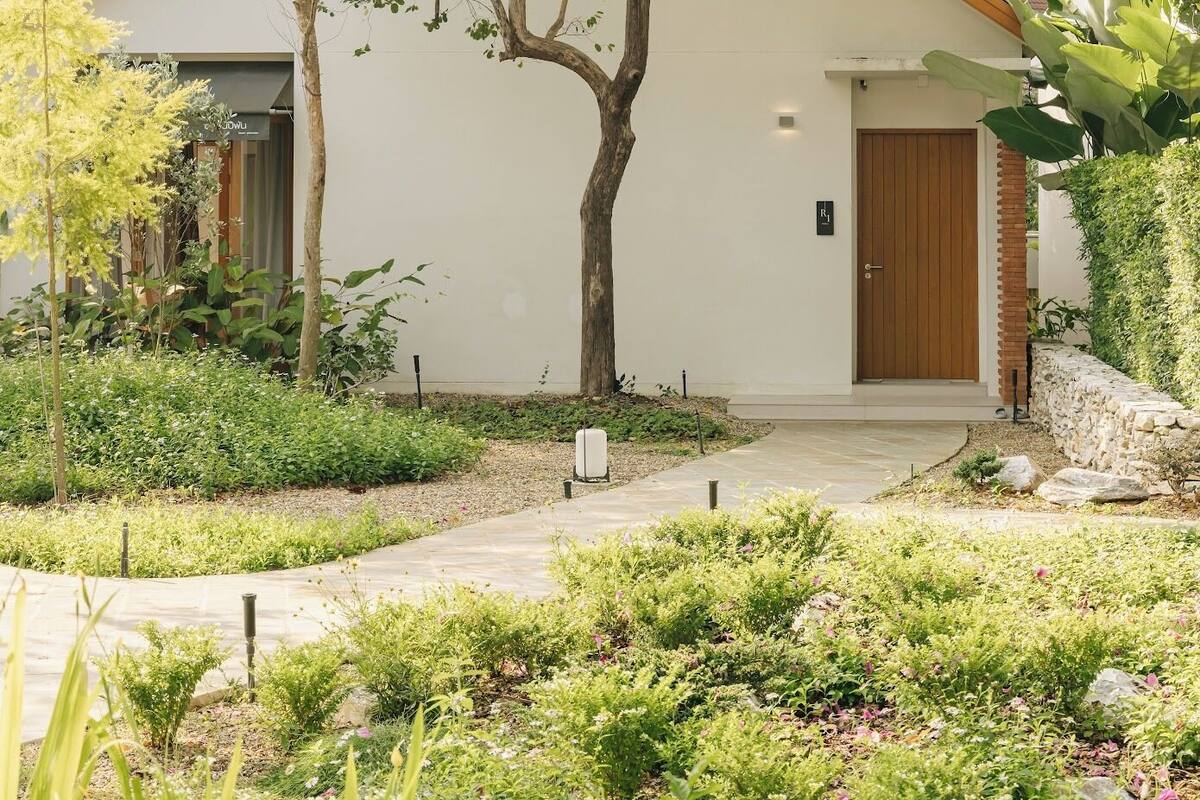 A white building with a wooden door and a small porch.