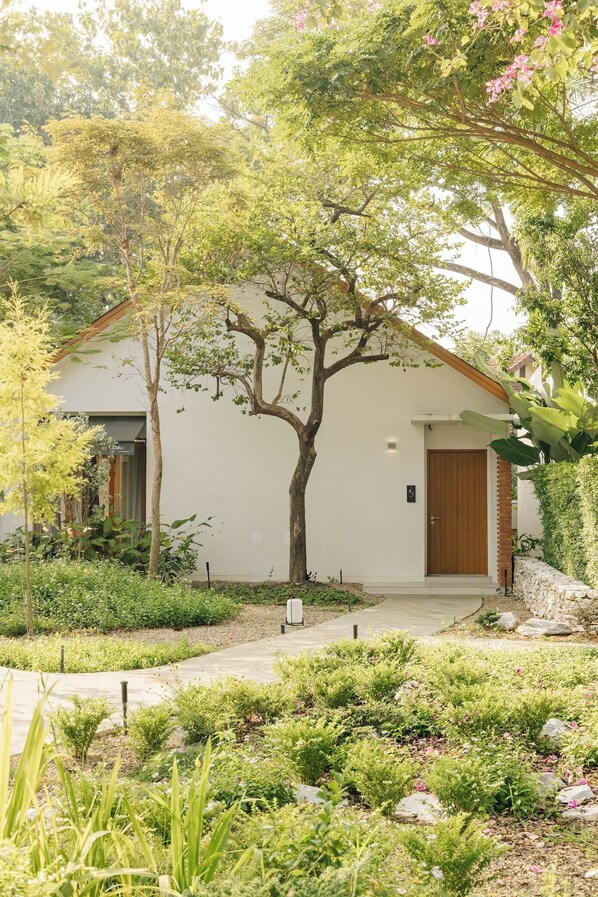A white building with a wooden door and a small porch.