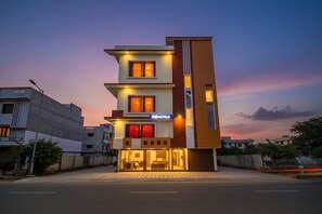 Un hôtel moderne à la façade sobre, doté de nombreuses fenêtres et d’une enseigne « Fab Hotels » bien visible.