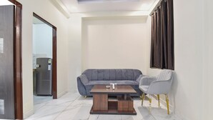 Un salon moderne avec un canapé gris, une table basse en bois et un fauteuil gris.