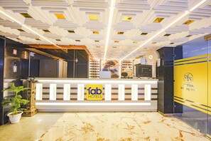 A hotel reception area with a modern design, including a reception desk, a plant, and a decorative ceiling. - FabHotel Dev Palace Naraina (New Delhi)
