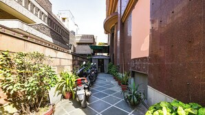 A narrow alleyway with potted plants and parked scooters. - Fabhotel Green Park (New Delhi)