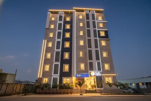 A multi-story hotel with a modern facade, illuminated windows, and a sign for 'FabHotels'. - Fabhotel Frendz (Hyderabad)