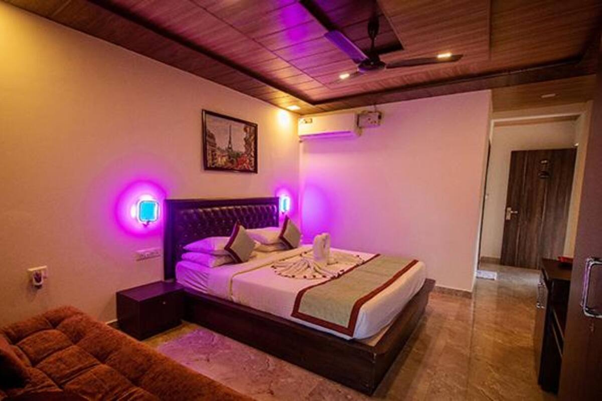 Ein Schlafzimmer mit Bett, Nachttischen, Kopfteil, Deckenventilator und einer Tür.