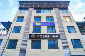 Een gebouw met een bordje voor 'fabHOTELS' en 'PEARL INN'.