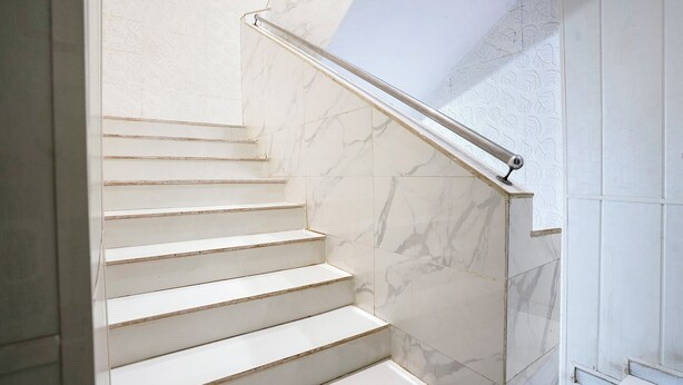 A staircase with white steps and marble walls. - Fabhotel Hans Residency (Mumbai)