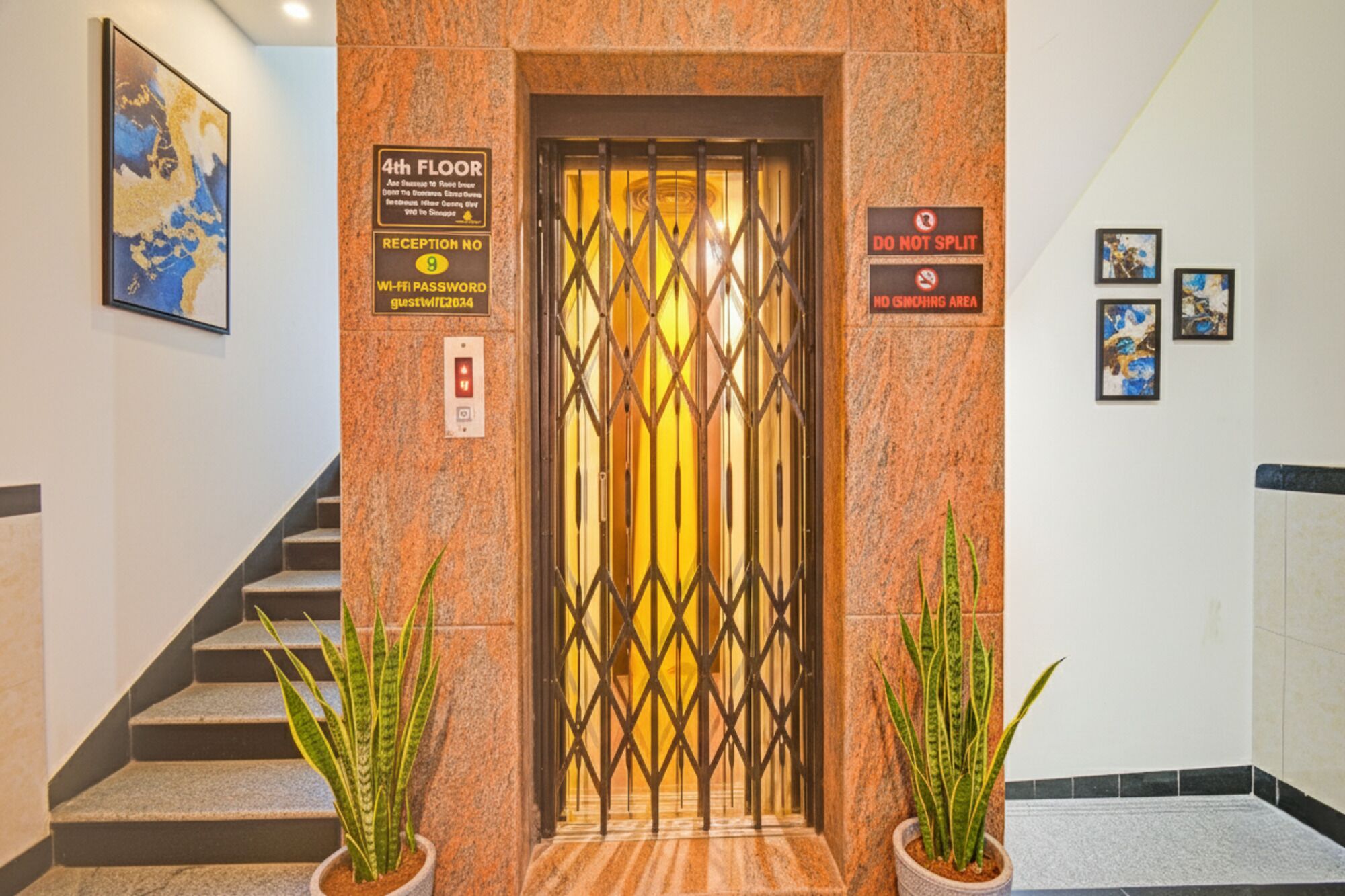 An elevator entrance with a reception sign, a 'Do Not Split' sign, and a 'No Smoking Area' sign.