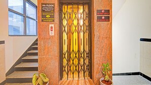 An elevator with a reception sign, a no smoking sign, and a Wi-Fi password sign. - Fabhotel Aig Broholic (Hyderabad)