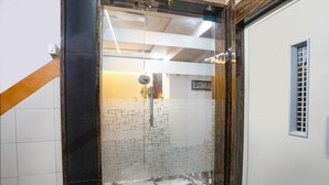 A glass-enclosed shower area with a tiled floor and a small window. - FabHotel Alpine I - Inside Shivani Avenue (Ahmedabad)