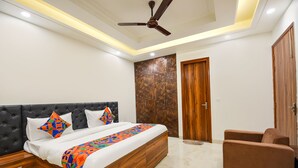 Un dormitorio con cama, ventilador de techo, armario y zona de estar.