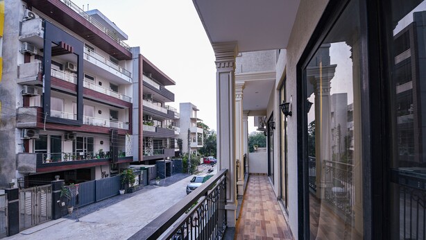 Un balcón con vistas a edificios cercanos y a una calle.