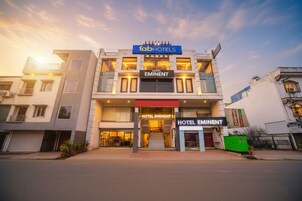 A modern hotel with a prominent 'fabHOTELS' sign, 'HOTEL EMINENT' branding, and a staircase leading to the entrance.