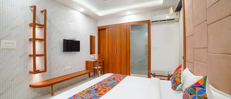 Een moderne slaapkamer met een groot bed, houten meubels, een televisie en een kledingkast.