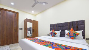 A bedroom with a bed, a wardrobe, and a ceiling fan.