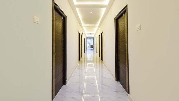 A long, narrow hallway with a polished marble floor and modern lighting.