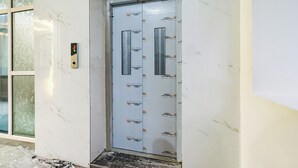 A door with a digital lock and a vertical handle, surrounded by a white wall with a JSL logo.