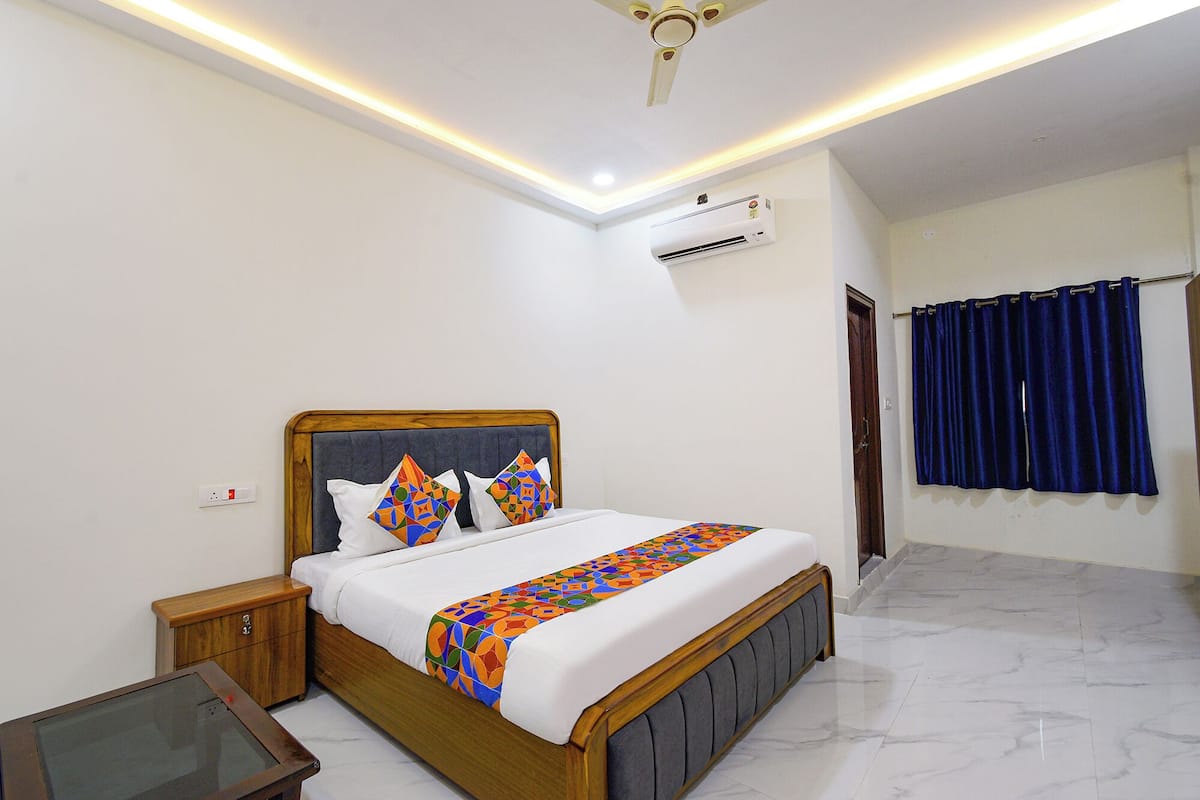 A neatly arranged bedroom with a bed, bedside table, and a small desk.