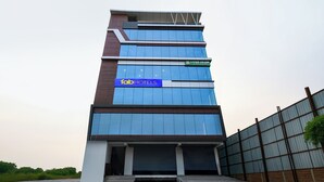 A multi-story hotel with a modern design, featuring a prominent 'fab hotels' sign on the facade.