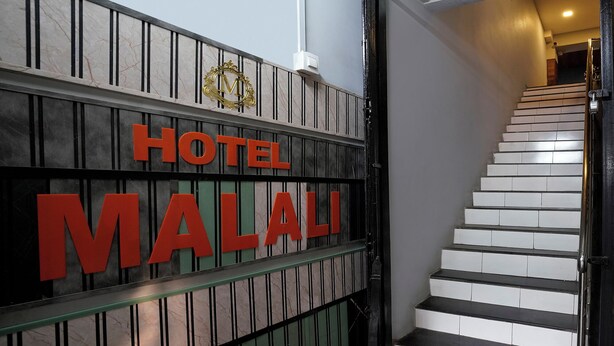 A staircase leading to a hotel entrance with a sign that reads "HOTEL MALALI". - FabHotel Malali Residency (Mumbai)