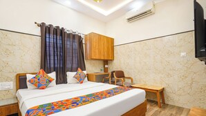 A hotel room with a bed, a wooden cabinet, a desk, and a chair. - FabHotel Classic Heights - Near Yelahanka Railway Station (Bangalore)