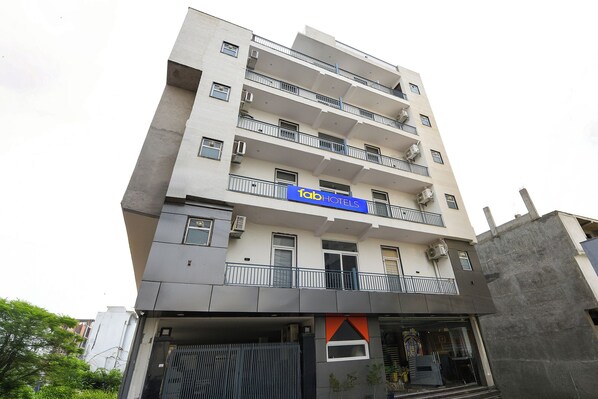 A multi-story building with a sign for 'fab hotels'. - Fabhotel Sk Residency (Gurugram)