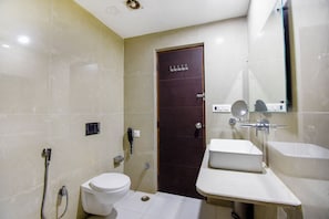 A compact bathroom with a toilet, a sink, and a shower.