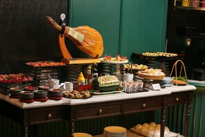 A buffet with various dishes, including a large roasted pig, a watermelon carved into a sign, and several trays of food. - La Mejor Indochine Hotel (Hanoi)