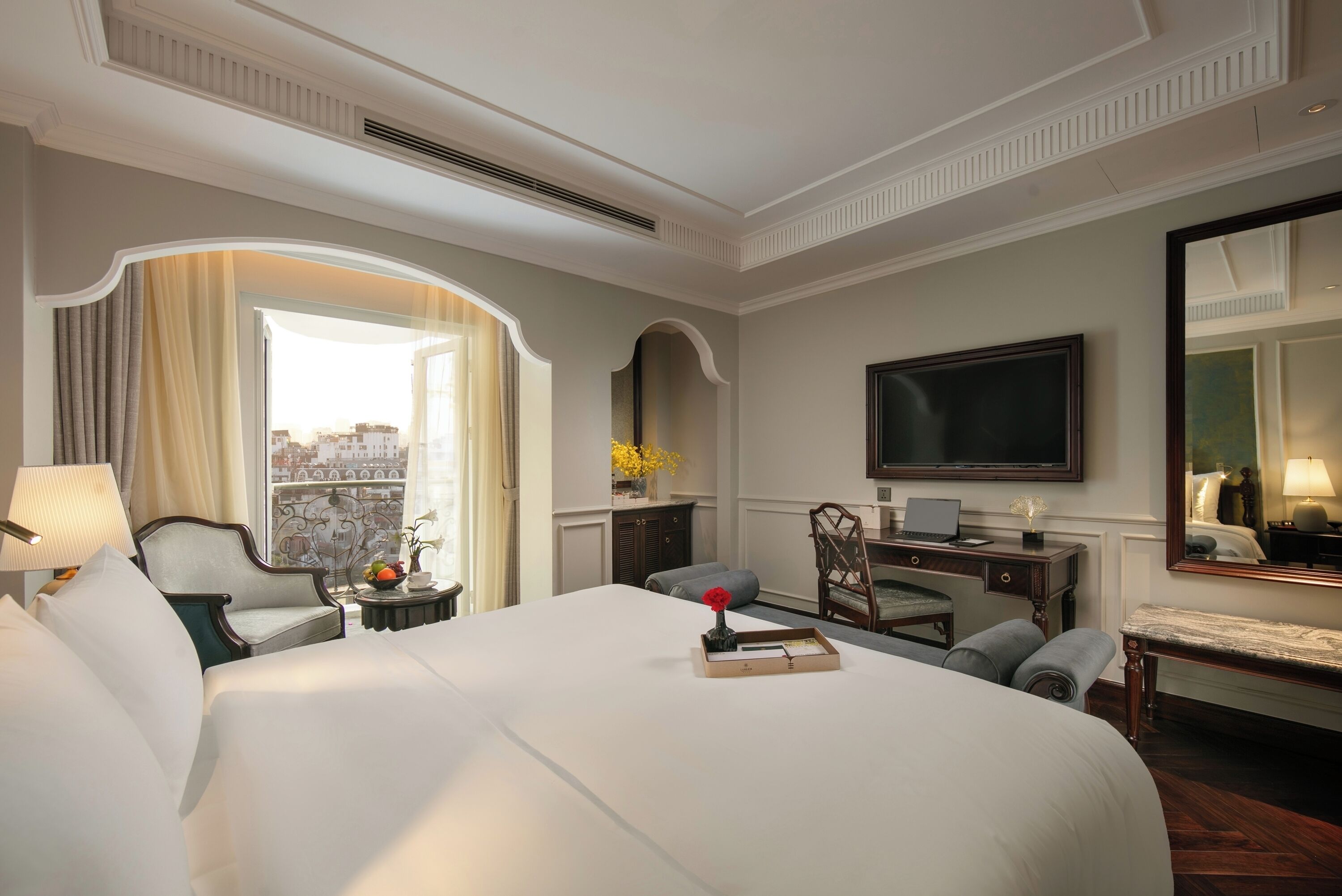 Une chambre d’hôtel avec un grand lit, un bureau, une télévision et une vue sur la ville.