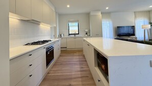 Una cocina moderna con armarios blancos, una isla central y un horno empotrado.