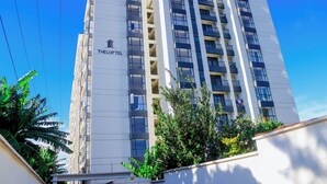 Un hôtel à plusieurs étages, doté de balcons et d’une enseigne indiquant « THELOFT ».