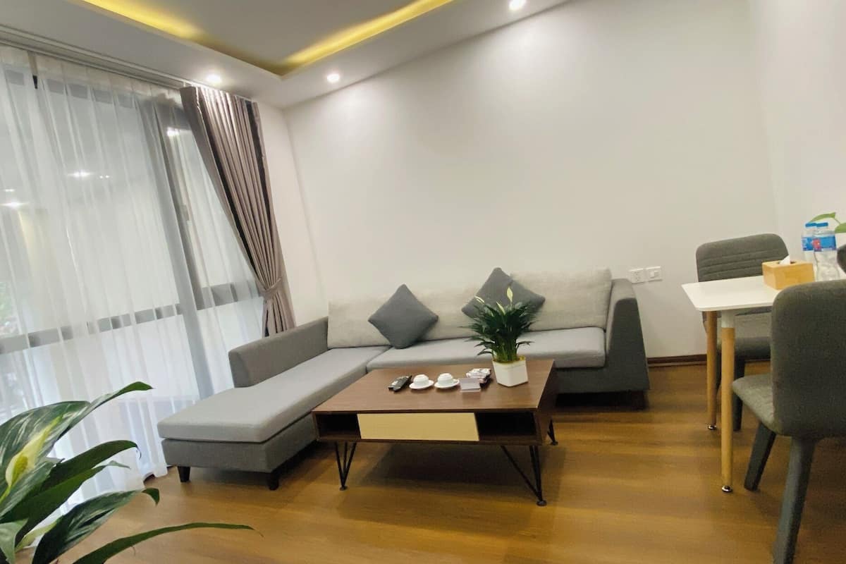 A modern living room with a sectional sofa, a coffee table, and a dining area with a table and chairs.