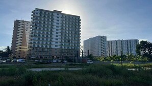 Un edificio residencial alto con varios balcones y techo plano.