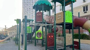 Un parque infantil con diversas estructuras de juego, incluyendo toboganes, zonas de escalada y una sección con red.
