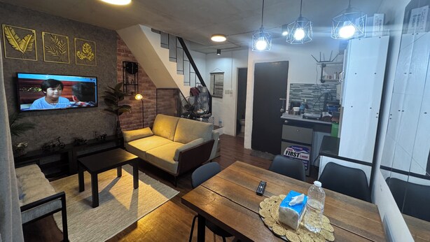 Un salon moderne comprenant un téléviseur, un canapé, une table basse et une table à manger.