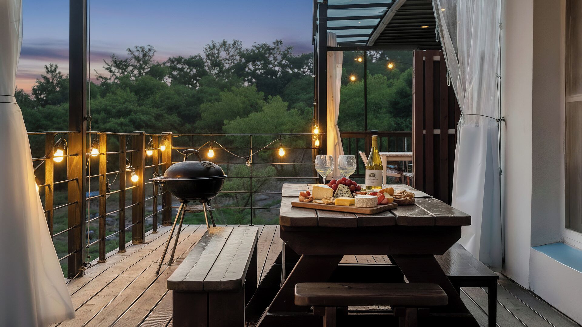 An outdoor patio with a grill, wooden table, and string lights.