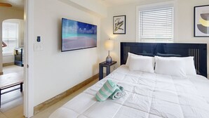Une chambre à coucher avec un lit, un tableau, une lampe et une fenêtre avec des stores.