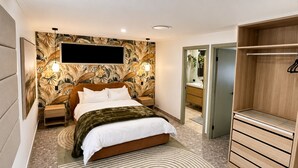 A modern bedroom with a bed, a wooden wardrobe, a vanity, and a wall-mounted TV.