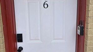 Una puerta blanca con el número 6, una cerradura y un candado.