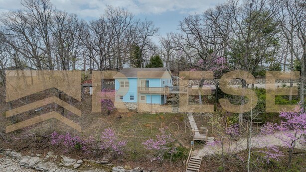 A two-story house with a blue exterior and a balcony. - Mid-Century Cabin, Pet Friendly Mid-Century Cabin (Lake Ozark)