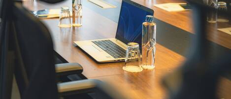 A conference table with a laptop, water bottles, and documents.