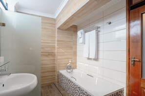 Separate tub and shower, free toiletries, slippers, towels - Karen Plains Hotel (Nairobi)