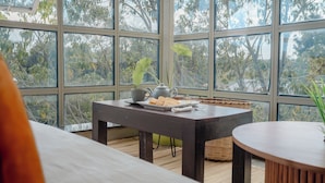 A room with a large window, a table with a teapot and plates, and a wicker basket. - Karen Plains Hotel (Nairobi)