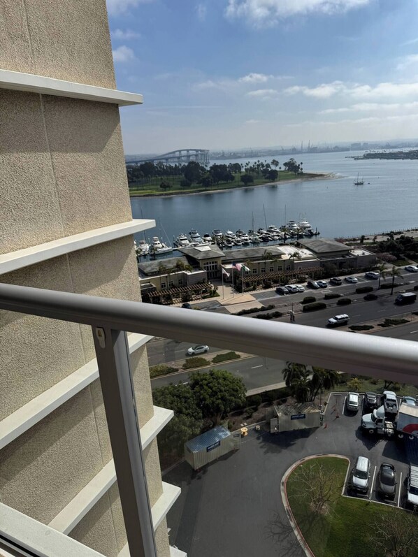 Un edificio alto con vistas a un puerto deportivo y un puente a lo lejos.