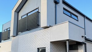 Un bâtiment moderne à deux étages, doté d’une façade en briques, de grandes fenêtres et d’une clôture en bois.