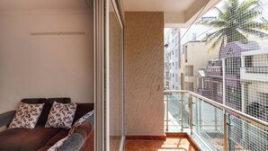 Un balcon offrant une vue sur le paysage urbain et les palmiers.