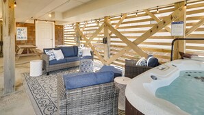 Un espace bien-être avec des meubles en osier, un jacuzzi et une terrasse en bois.