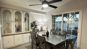 A dining area with a table and chairs, a ceiling fan, and a view through a glass door. - Cozy 3BDR/2BATH in N Phoenix. 8mi from Mayo Clinic (Phoenix)