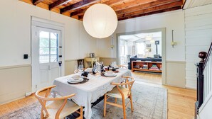 A dining area with a wooden ceiling, a large hanging light fixture, and a table set for a meal. - Walk to Vly Creek: Catskills Getaway w/ Porch (Fleischmanns)