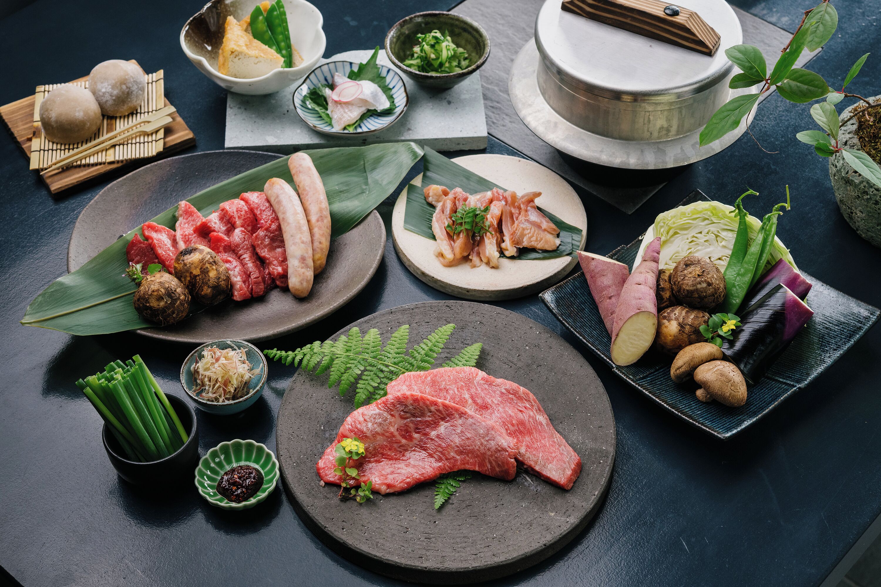A variety of food items including meat, vegetables, and condiments arranged on a table.