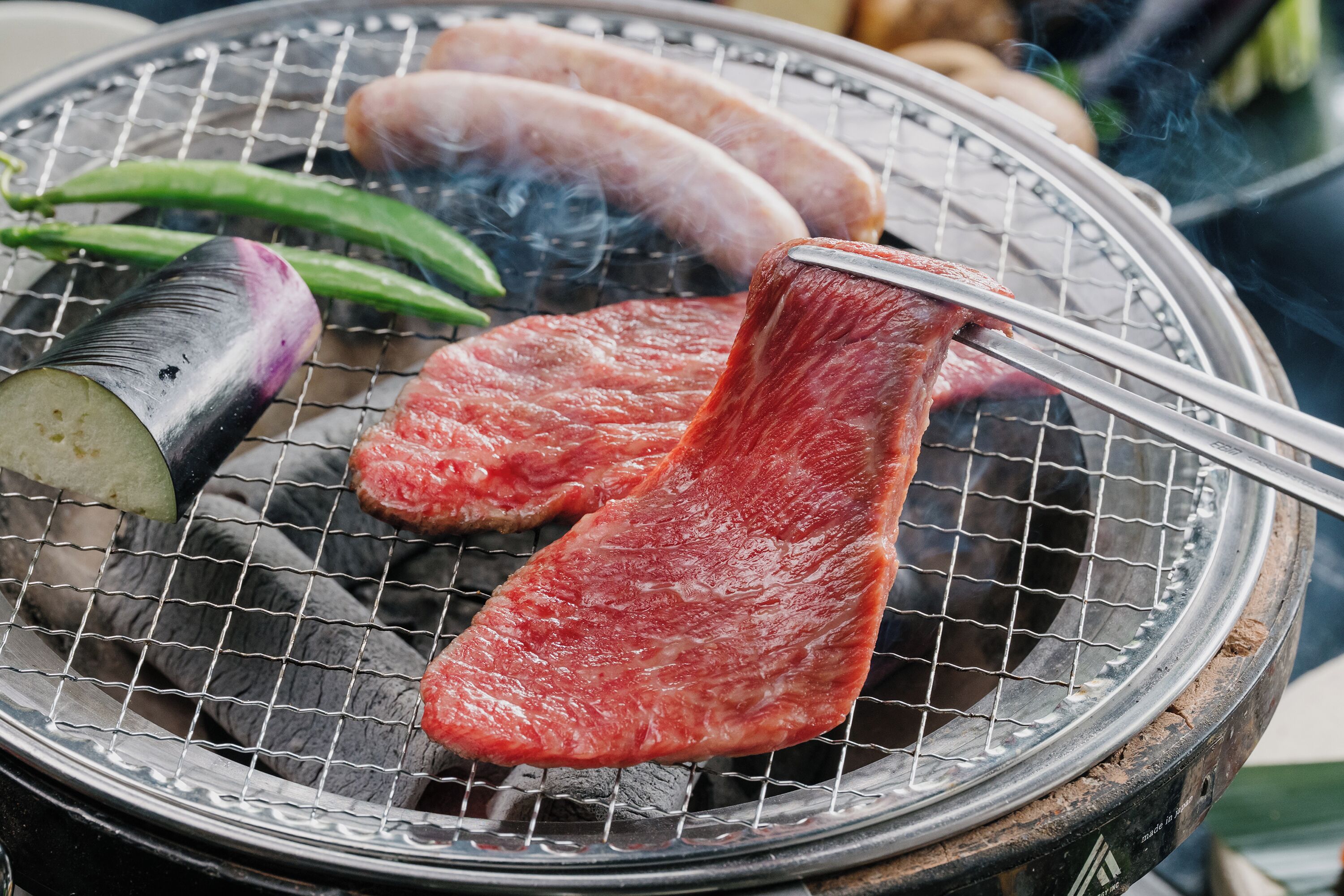 A grill with various meats and vegetables.